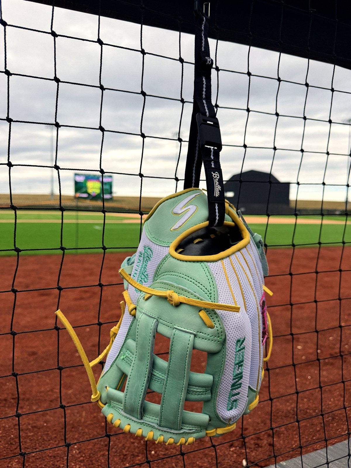 Mint glove clipped to a dugout fence